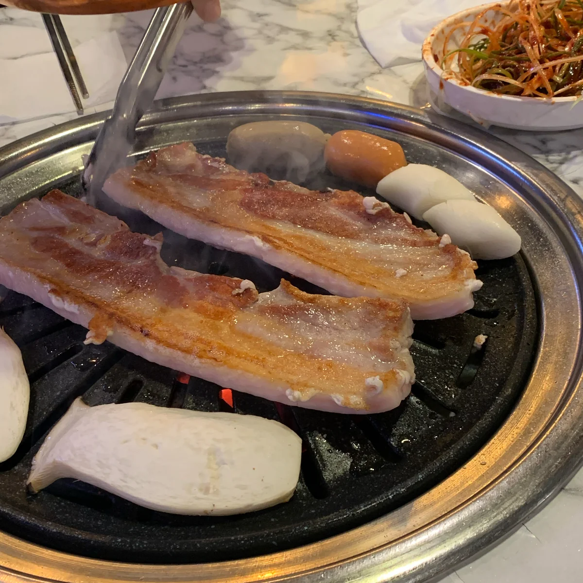 Cliente feliz disfrutando de deliciosa carne de cerdo en el salón gogi