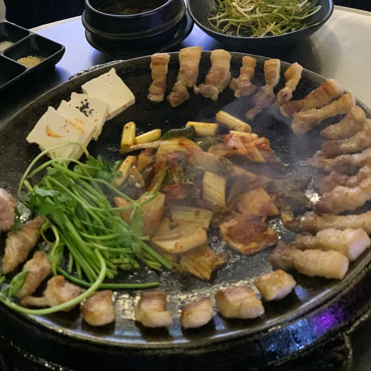 Staff meticulously preparing pork belly at Sotdon (솥돈)